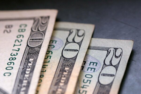 Three dollar bills on a gray background