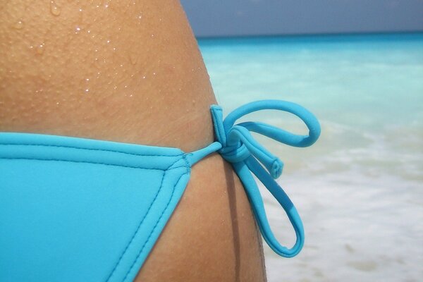 Ragazza in costume da bagno blu sul mare