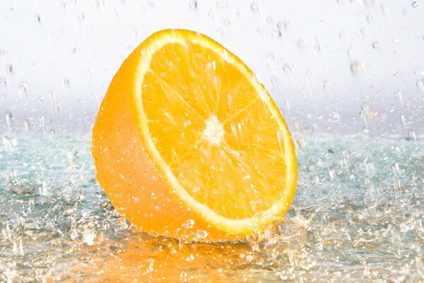 Half an orange in transparent splashes