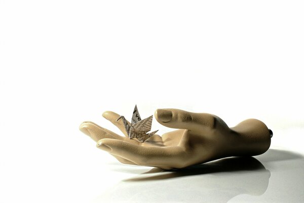 Paper crane in hand on a white background