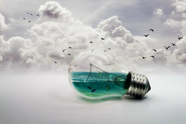 A light bulb with sea water and fish on a background of clouds and birds