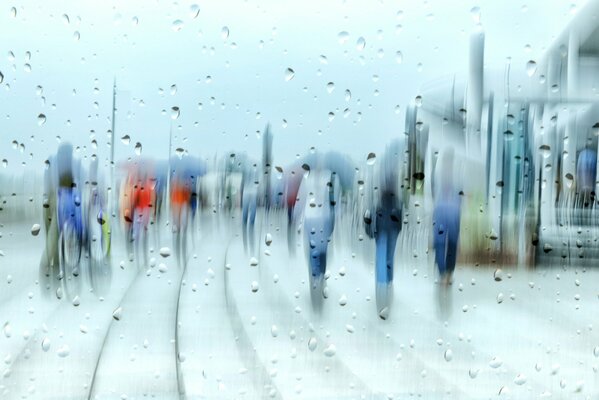 Abstracción la gente en la ciudad detrás de las gotas