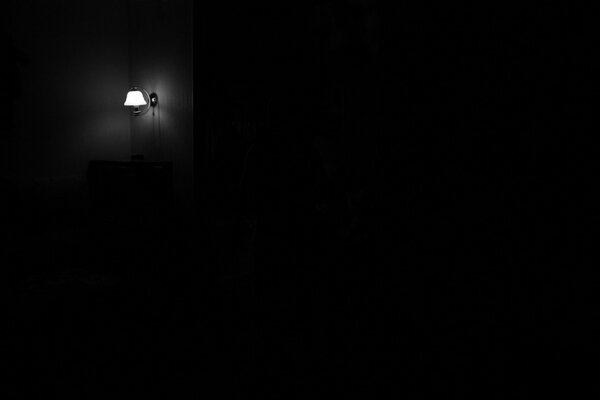 A dark room with a lamp on