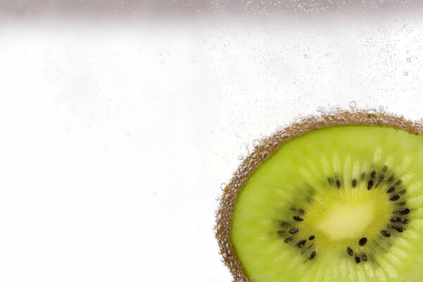 Green kiwi in water with bubbles