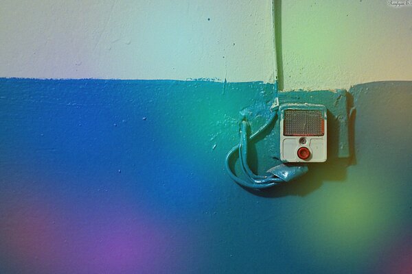 A bell on a bright rainbow wall