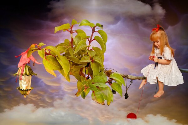 Red-haired girl on a branch playing with a ball