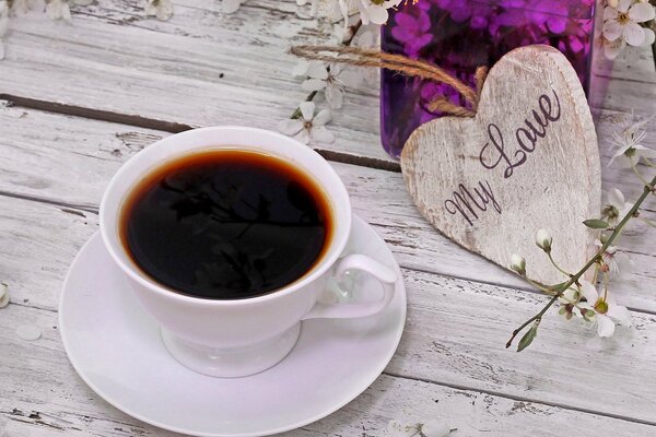 Tazza di caffè su un bellissimo sfondo di tavolo e fiori