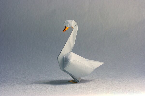 White origami goose on a gray background