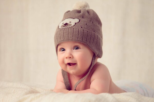 A small child in a cute hat smiles