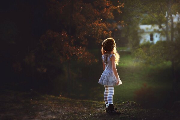 Bambina sullo sfondo della natura che guarda in lontananza