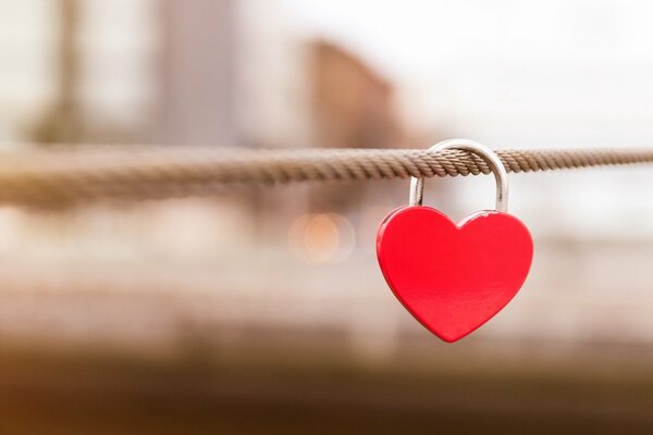 Lock in the form of a red heart on a steel beam