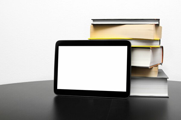 Immagine minimalista. Tablet e libri sulla scrivania