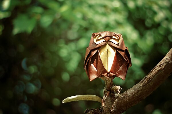 Búho estilo origami sentado en una rama en un bosque verde