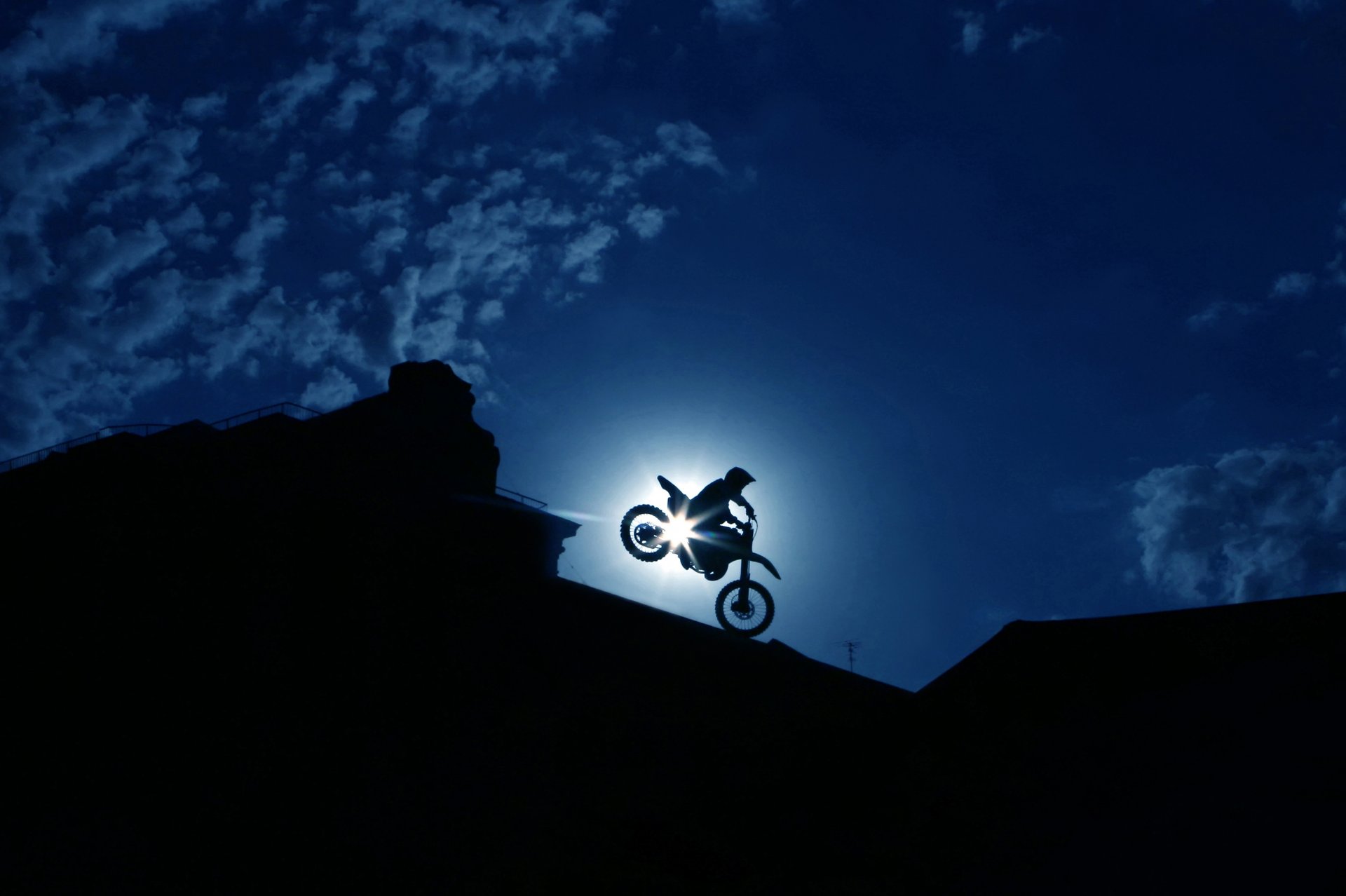 silhouette uomo pilota moto estremo bici motociclista spettacolare abile manovra acrobazia notte città cielo nuvole bellissimo sfondo carta da parati