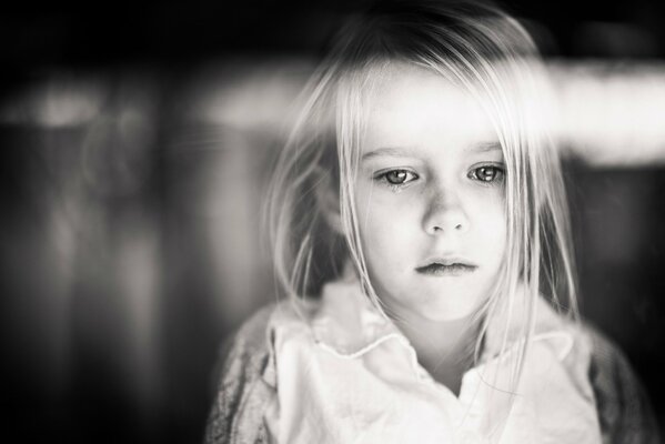 Black and white photo of a girl. Sad look down