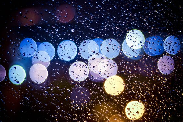 Lumières de nuit à travers les gouttes de pluie
