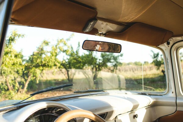 Retro car with a view of the landscape and the reflection of a couple in the mirror
