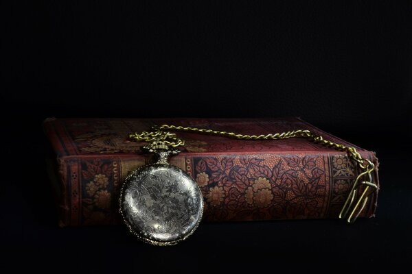 Taschenuhr mit Kette auf dem Buch