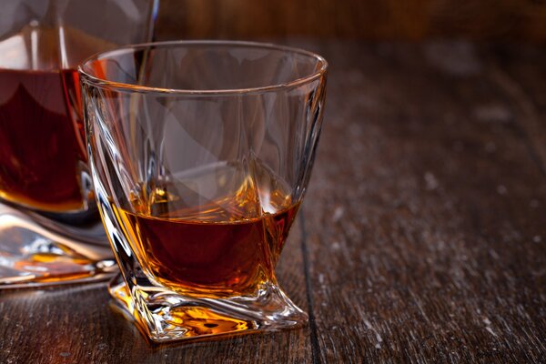 A glass of whiskey on a brown table