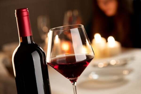 A bottle of red wine with a glass