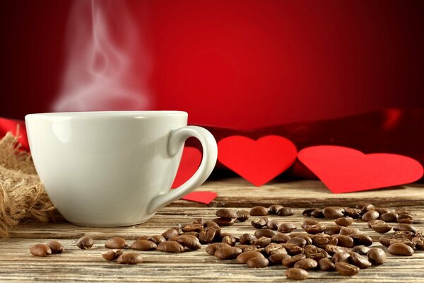 Bere caffè in una tazza bianca con vapore su uno sfondo di cuori rossi