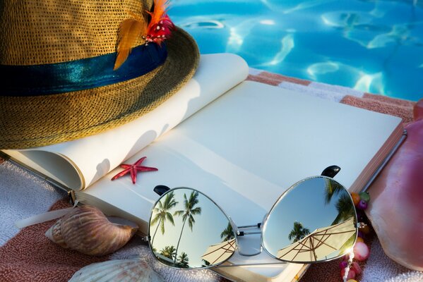 Summer marine composition of a blank notebook, hat and glasses