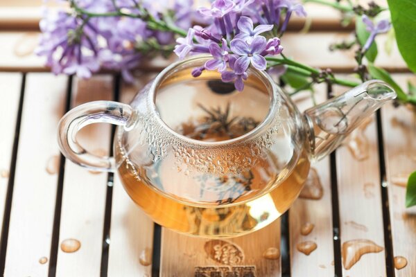Teapot and lilac flowers on a tray