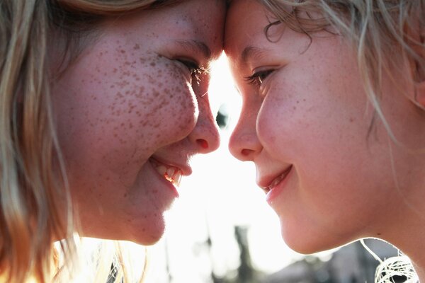 The smile of a freckled mother and the same daughter