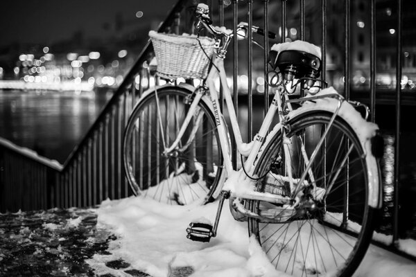 Vélo dans la neige sur le fond de la promenade de nuit