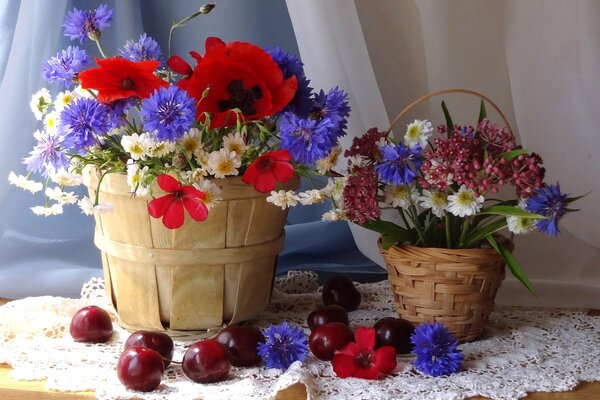 Hermosa naturaleza muerta: cestas de flores y bayas