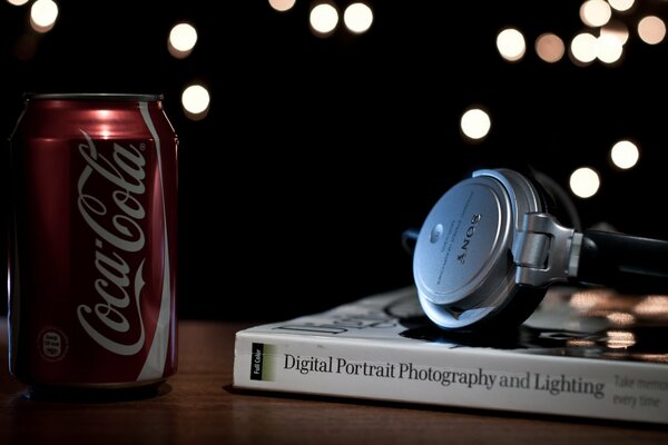 Auriculares en el fondo de un libro con una lata