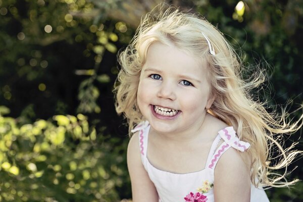 Retrato de una niña sonriente contra el bosque