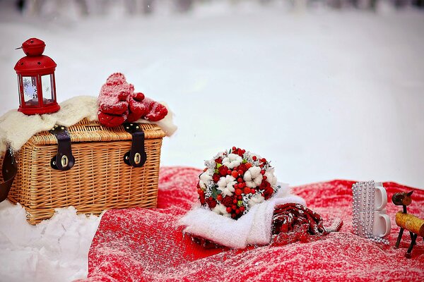 Love. wedding in winter. the bride s bouquet with red mountain ash. red flashlight and mittens on a wicker basket