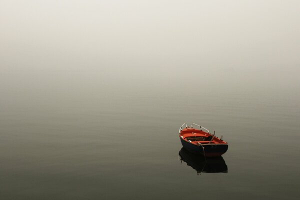 Paisaje tranquilo: un barco solitario en la niebla de la mañana