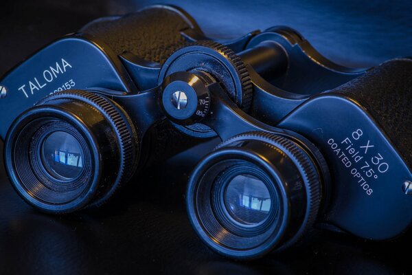 Binocolo nero con ottica su sfondo macro