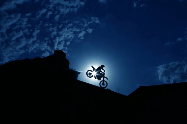 A racer performs a stunt on the background of a night city