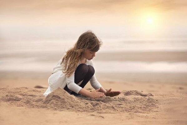 Ragazza che fa la creatività sulla spiaggia