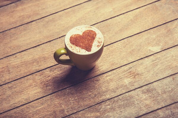 Tasse de café avec un motif sur la boisson en forme de coeur