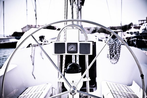 Large steering wheel on the background of boats and the sea