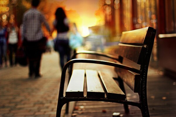 A bench against the background of a sunset, a girl and a guy