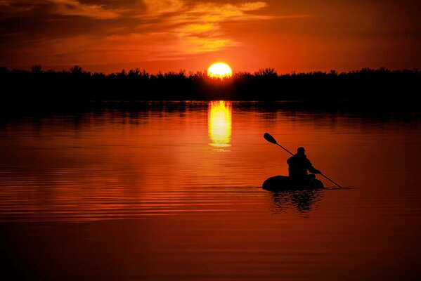 Floating on the waves behind the scarlet sun