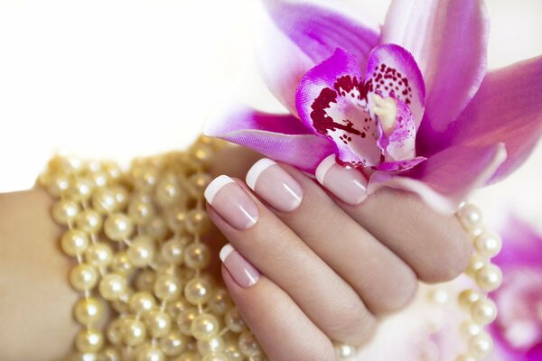 Mano femminile con manicure tiene il fiore