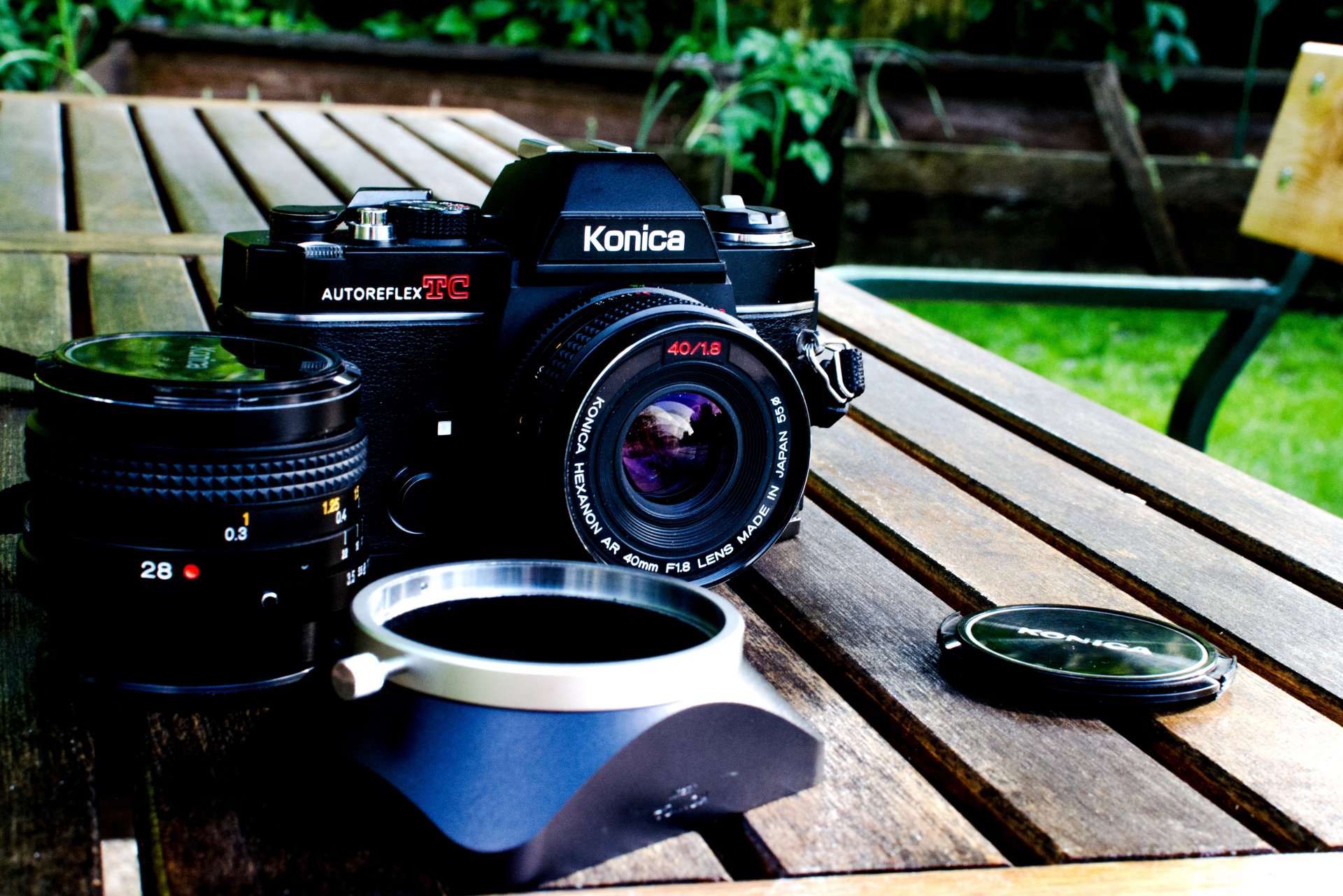 upplies table board a camera konica the camera lens cap background blur