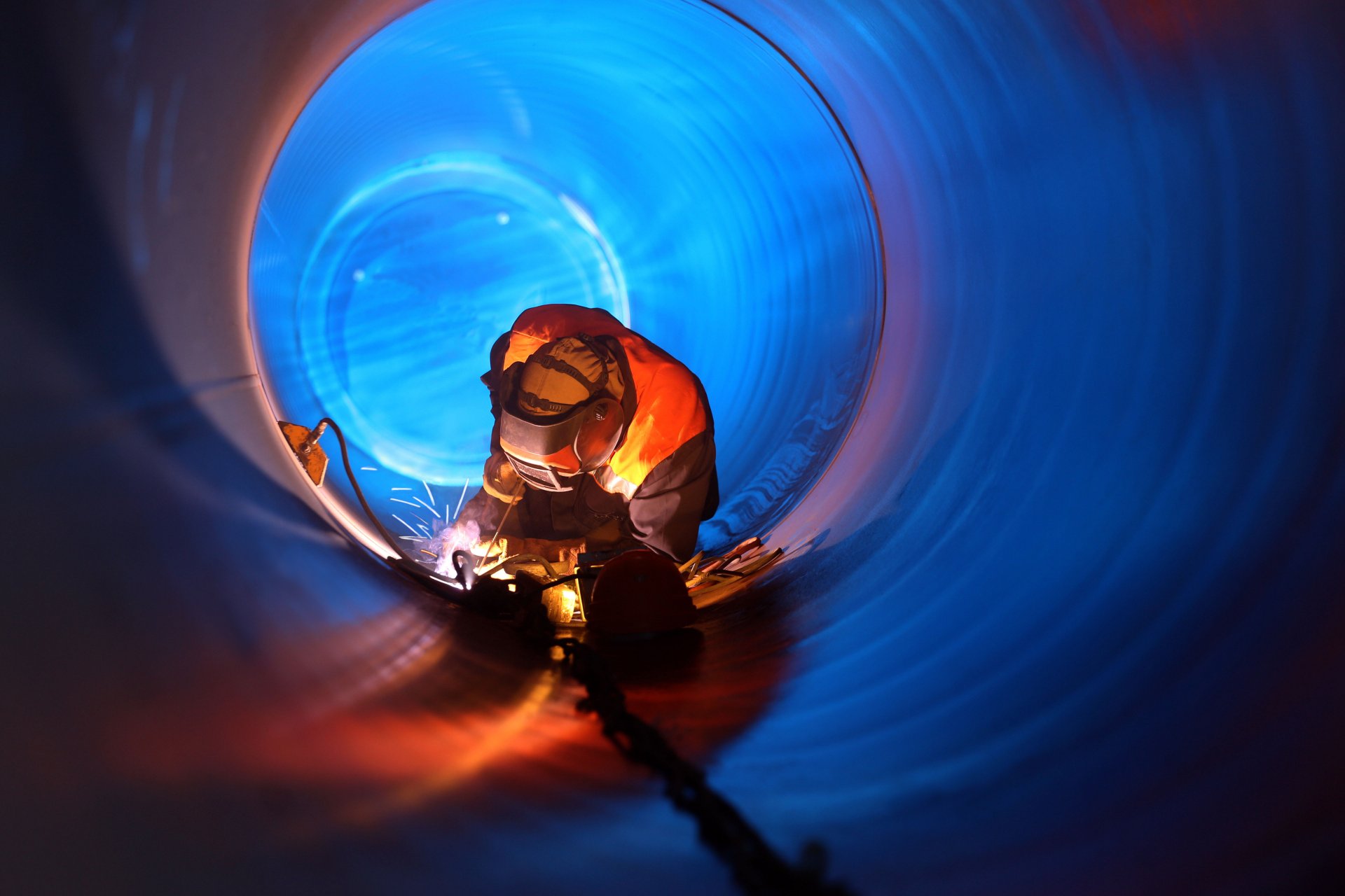 welder experienced mounting of the pipeline performs connection docking metal real estate light sparks beautiful background mission possible wallpaper