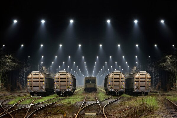 Night railway cars among the searchlights