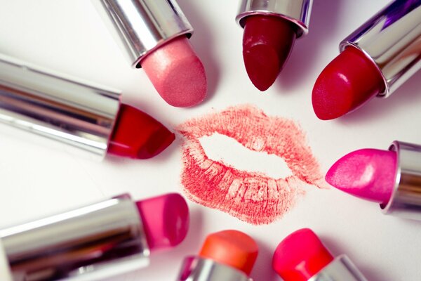 Around the red lip print is a multi-colored palette of lipsticks