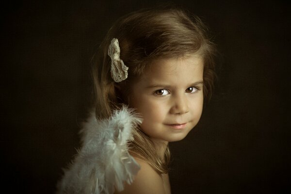 Una serie de pequeños Ángeles. Retrato de una niña con el pelo oscuro