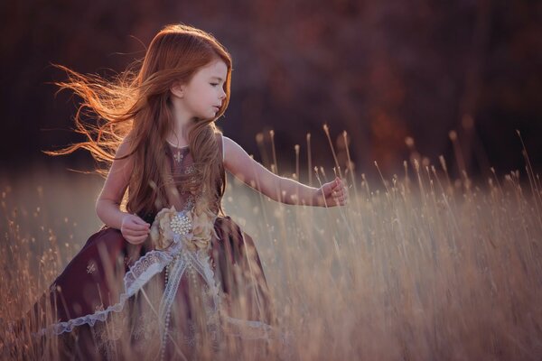 A red-haired girl runs through an autumn field