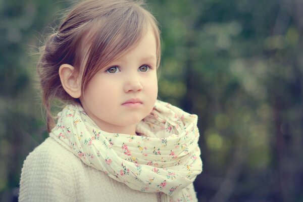 A beautiful girl in a scarf with a delicate pattern