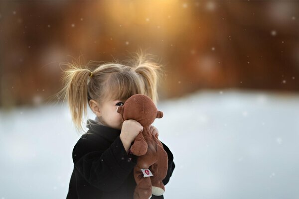 A little girl hugs her toy